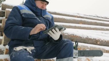 İşçi ile büyük kış orman günlüklerinde yığını tablet bilgisayarda