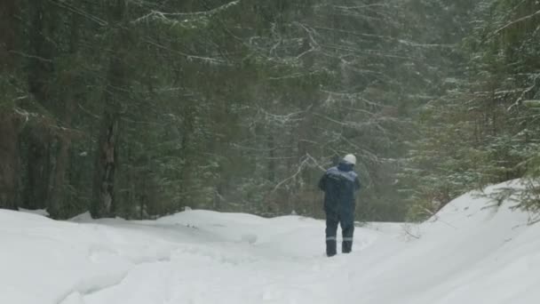 工人与链锯穿过冬季森林 — 图库视频影像