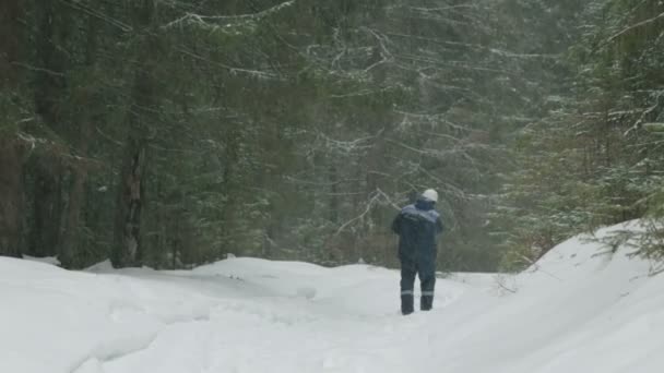 Arbetare Med Motorsåg Går Igenom Skogen Vinter — Stockvideo