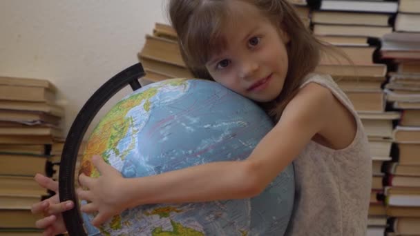 Μικρό κορίτσι που αγκαλιάζει μια υδρόγειο — Αρχείο Βίντεο