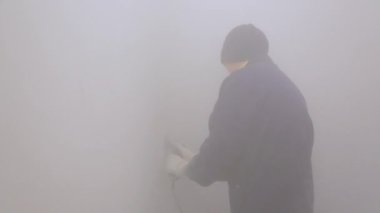 İşçi duvardan yüzey örtüsünü kaldırıyor