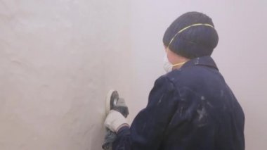 İşçi duvardan yüzey örtüsünü kaldırıyor