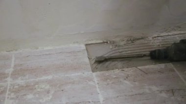 İşçi banyodaki döşemeyi söküyor.