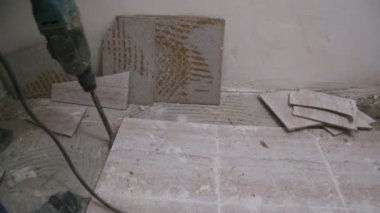 İşçi banyodaki döşemeyi söküyor.