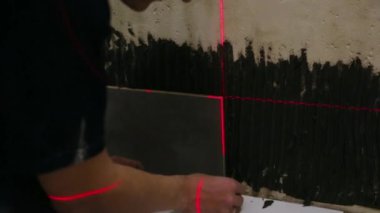 Duvara fayanslar döşeyen bir işçi