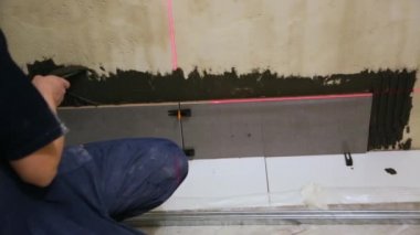 Duvara fayanslar döşeyen bir işçi