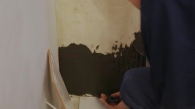 İşçi duvara tutkal yapıştırıyor