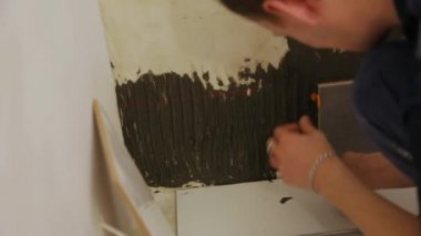 Duvara fayanslar döşeyen bir işçi