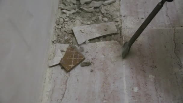 Arbeiter entfernt im Badezimmer alte Fliesen vom Fußboden — Stockvideo