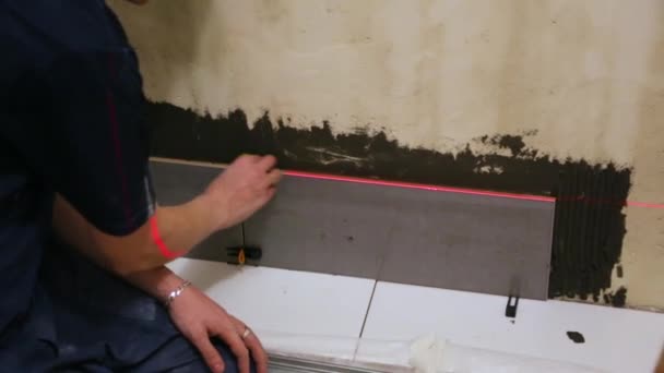 Arbeiter legt Fliesen an die Wand — Stockvideo