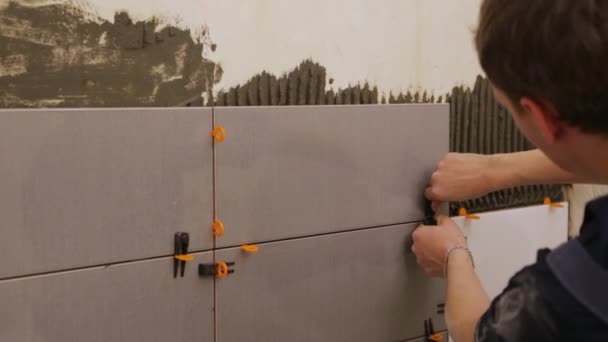 Worker laying tiles on the wall — Stock Video