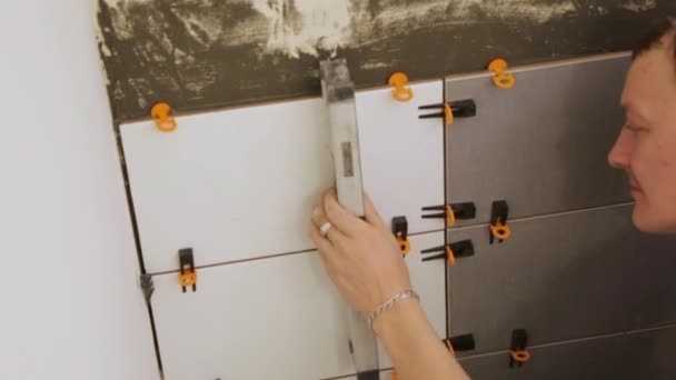 Trabajador de comprobación de nivel de colocación de azulejos en la pared — Vídeos de Stock