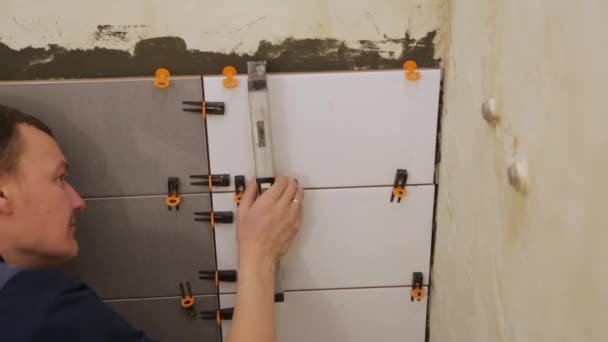 Trabajador de comprobación de nivel de colocación de azulejos en la pared — Vídeo de stock