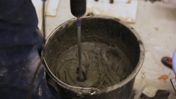 Рабочий смеси плитки клей в ведро — стоковое видео