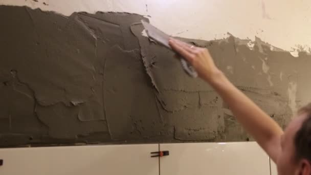 Εργαζόμενος βάζοντας κόλλα πλακιδίων στον τοίχο — Αρχείο Βίντεο