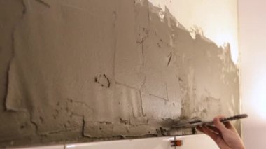 İşçi duvara tutkal yapıştırıyor