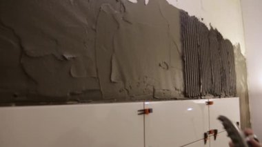 İşçi duvara tutkal yapıştırıyor