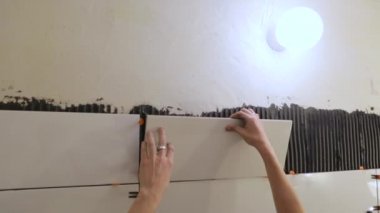 Duvara fayanslar döşeyen bir işçi