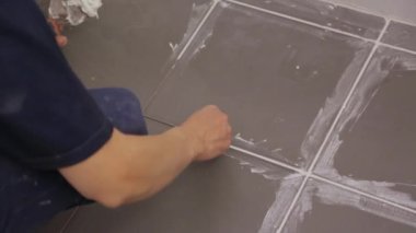 Yerdeki fayanslar arasında işçi troweling eklemleri