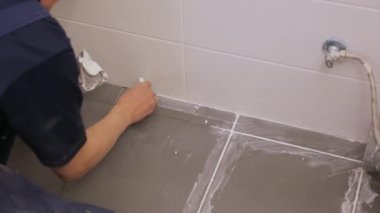 Yerdeki fayanslar arasında işçi troweling eklemleri