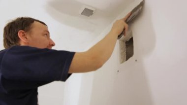 İşçi duvarı malayla kaplıyor.