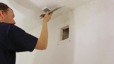 İşçi, tavanı malayla kaplıyor.