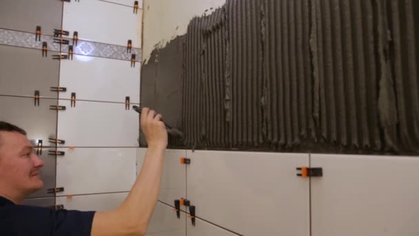 Travailleur mettre de la colle à carreaux sur le mur — Video