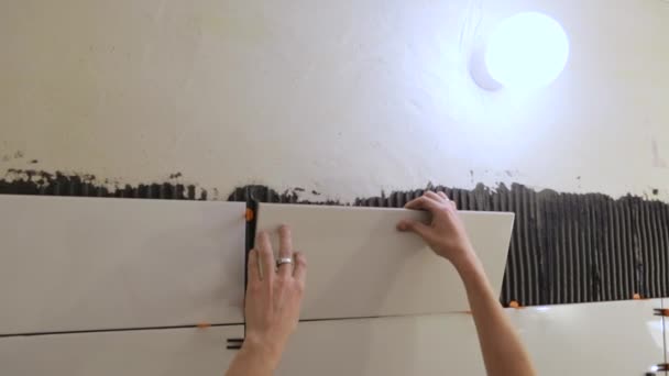 Pracovník pokládající dlaždice na zeď — Stock video