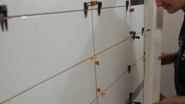 Arbetstagarkontroll nivå om kakel på väggen — Stockvideo