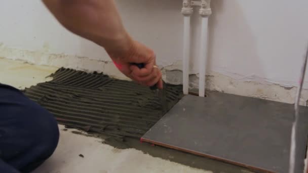 Arbeiter überprüfen Niveau der Verlegung von Fliesen auf dem Boden — Stockvideo
