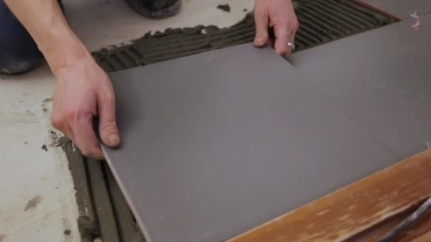 Werknemer legt tegels op de vloer — Stockvideo