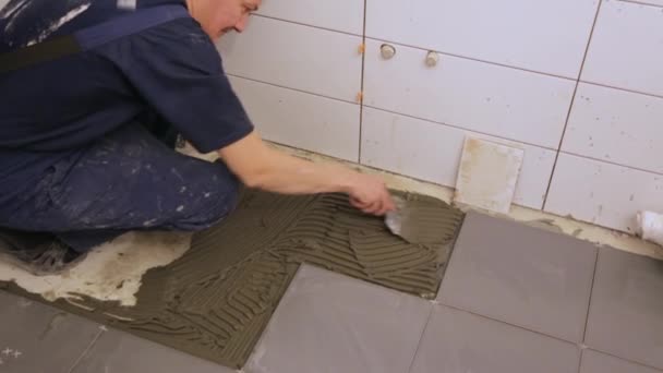 Trabajador poner pegamento azulejo en el suelo — Vídeo de stock