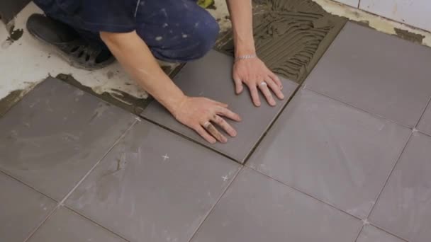 Trabalhador que coloca telhas no chão — Vídeo de Stock