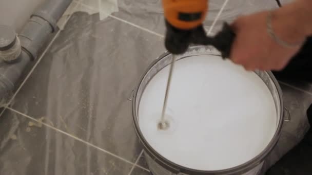 Mezclar pintura blanca en un cubo — Vídeo de stock