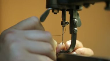 Ayakkabıcı dikiş makinesini hazırlıyor. Yakın çekim.