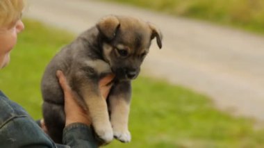 Elinde küçük bir köpek yavrusu tutan bir kadın