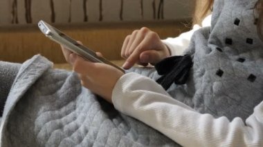 Kanepede akıllı telefonu olan küçük kız.