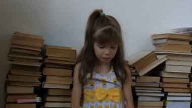 Yerde kitap okuyan küçük kız.