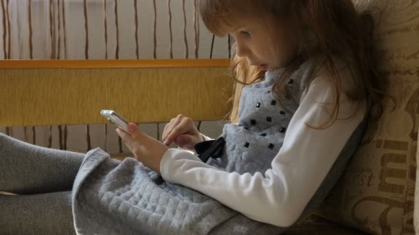 Bambina con smartphone sul divano — Video Stock