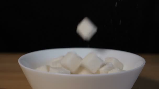Кубики сахара падают в миску — стоковое видео