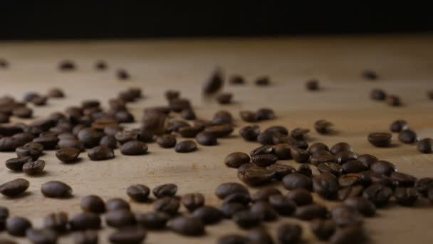 Koffiebonen vallen op een tafel in slow motion — Stockvideo