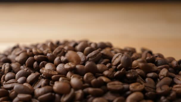 Granos de café cayendo sobre una mesa en cámara lenta — Vídeos de Stock