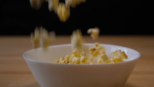 Попкорн падает в миску в замедленной съемке — стоковое видео