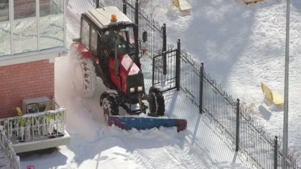 Trekker verwijdert sneeuw van loopbruggen — Stockvideo