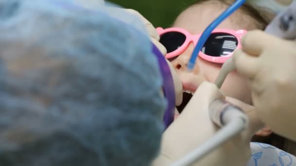 Niña en la silla del dentista teniendo su diente tratado — Vídeo de stock