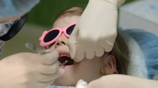 Bambina sulla sedia del dentista che si fa curare il dente — Video Stock