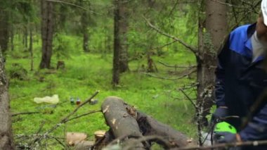 Ormanda çalışan testereli bir adam.