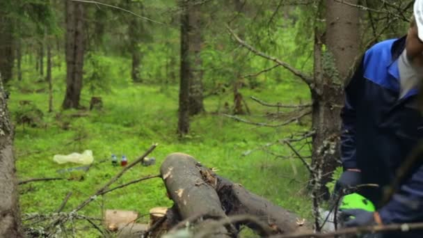 Hombre con motosierra trabajando en el bosque — Vídeo de stock