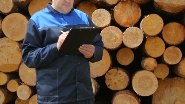 Arbeiter prallt mit Unterlage gegen Baumstamm — Stockvideo