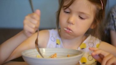 Kafede makarna yiyen küçük kız.